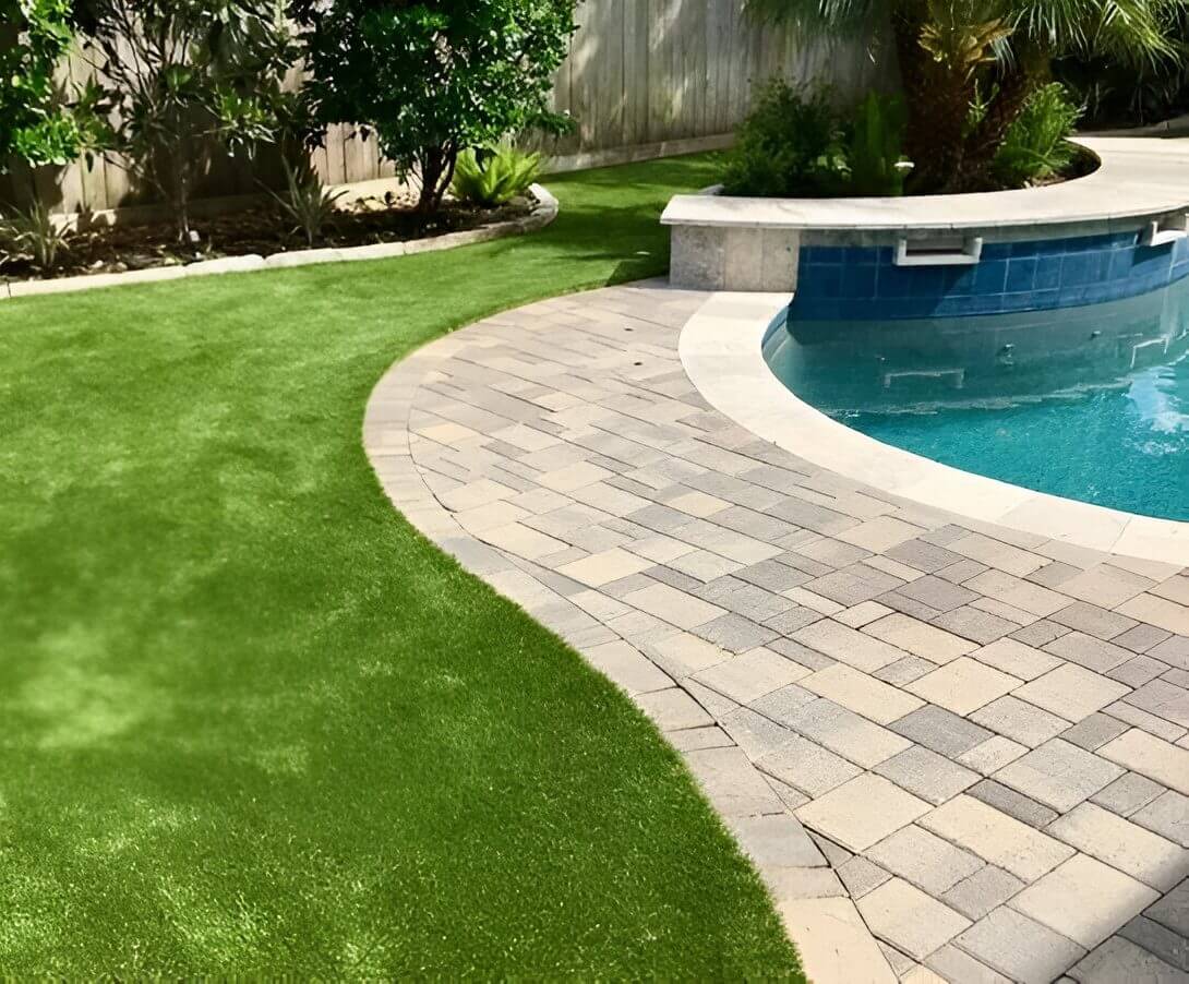 Backyard pool with paved and grassy area.