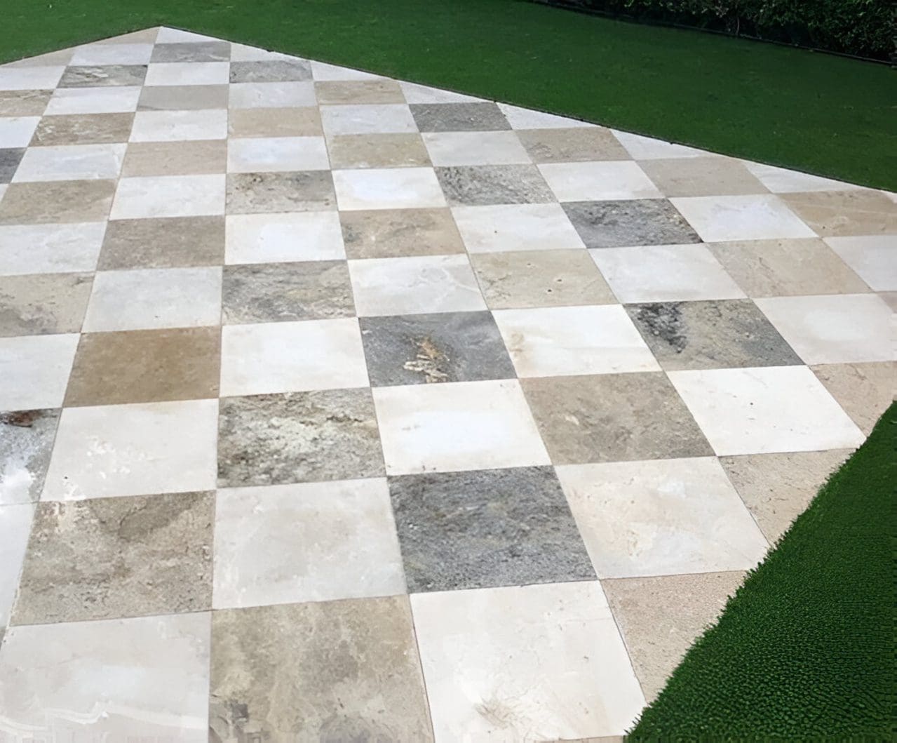 Checkerboard patio with grass border.