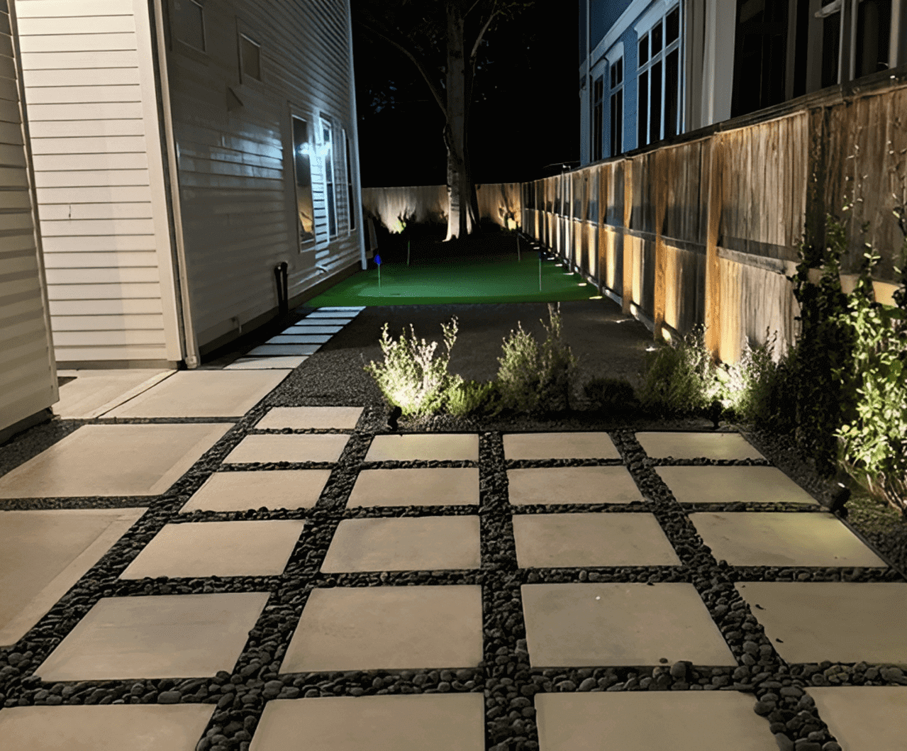Modern backyard patio with night lighting.