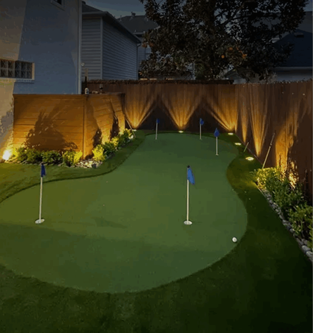 Backyard putting green with evening lights.