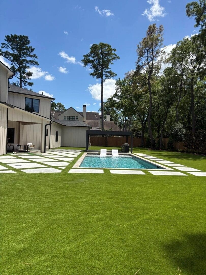 Modern backyard with pool and green lawn.