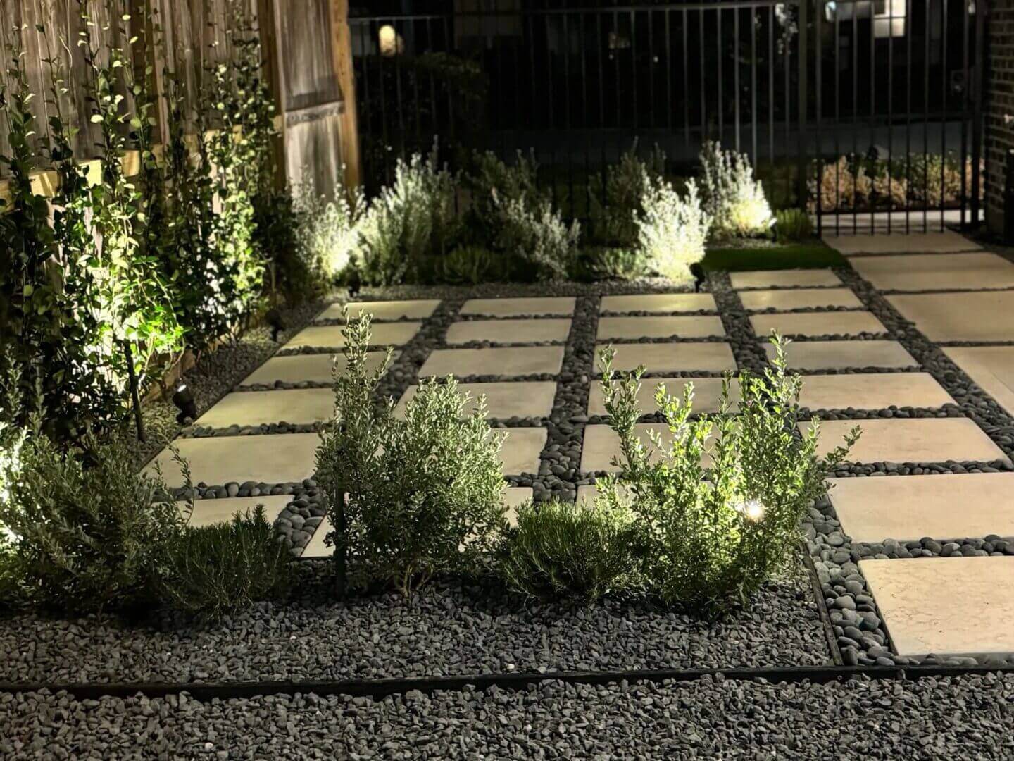 Illuminated garden pathway with decorative plants.