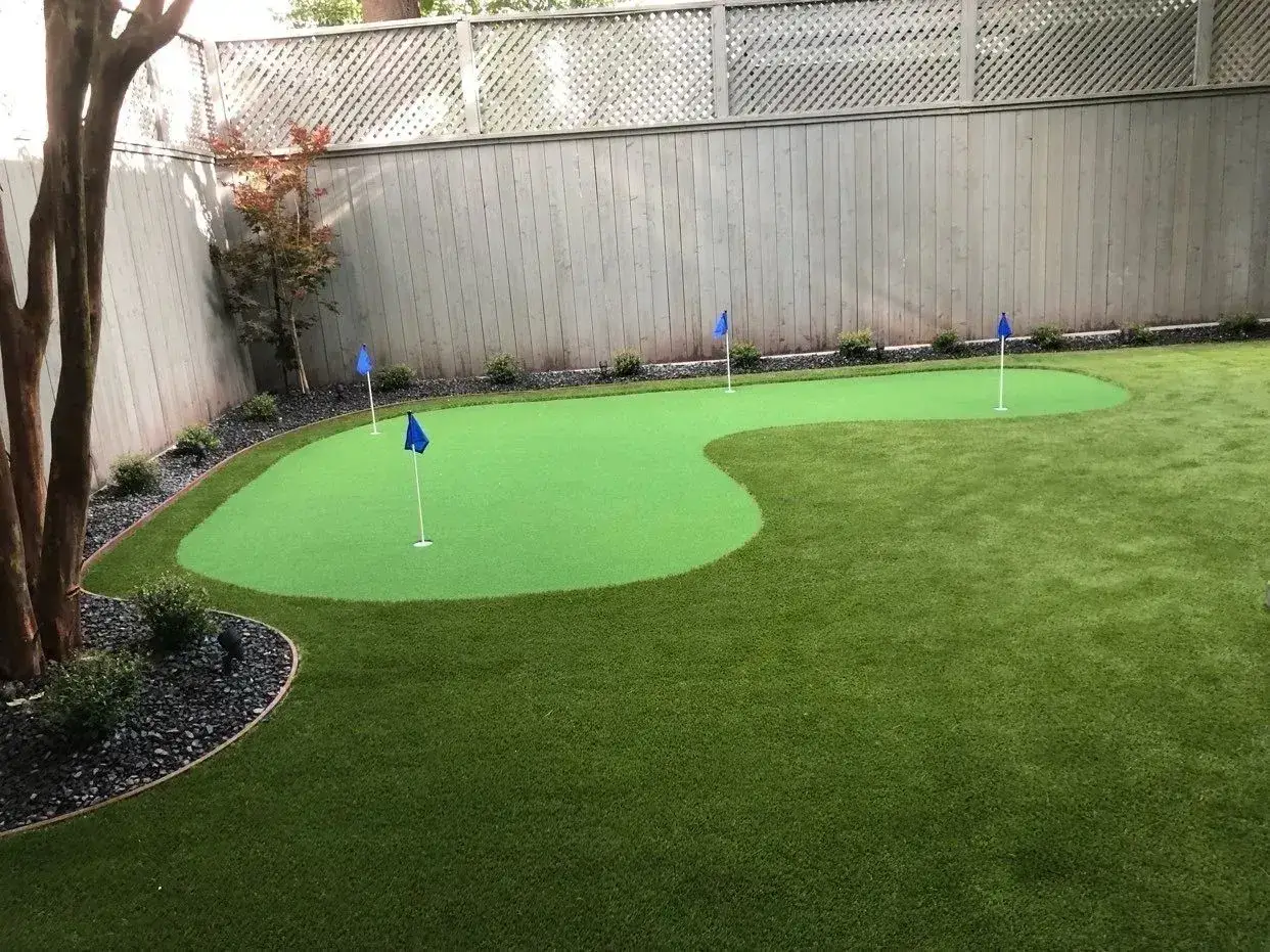 Miniature backyard putting green with blue flags.