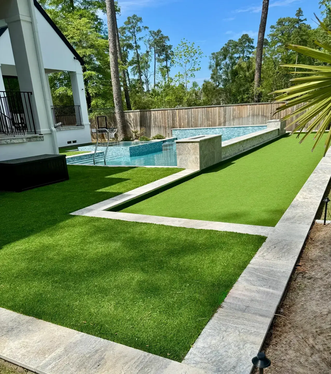 Modern backyard with a pool and manicured green lawn.
